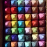 A colorful array of square pastels arranged neatly in a box, perfect for art projects.
